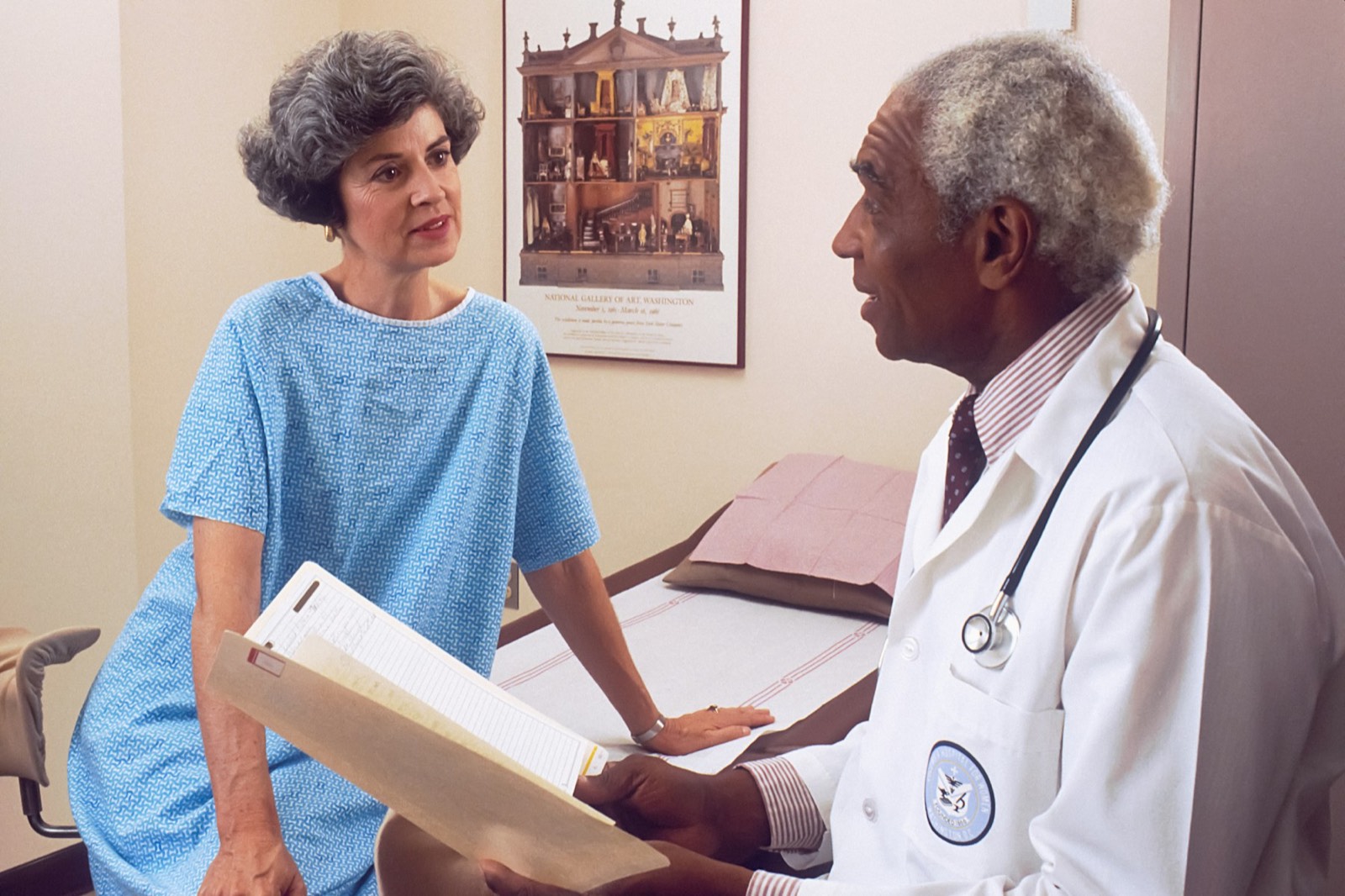 A doctor and a middle-aged man talking across a desk
